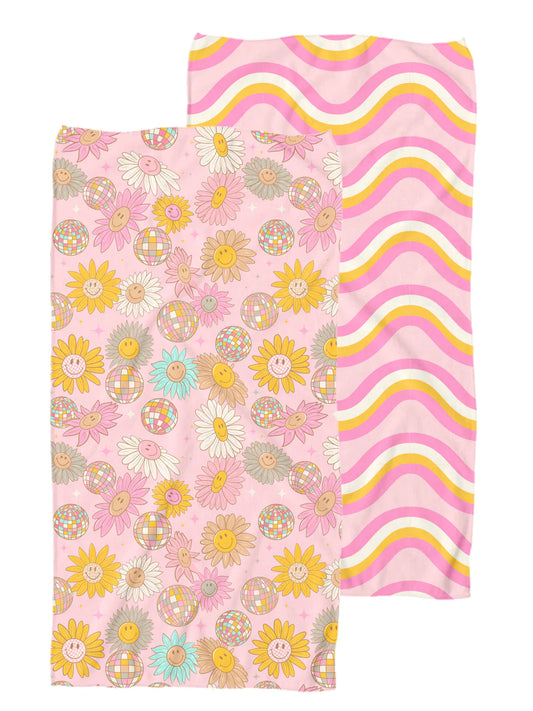 two sided towel. one side is pink base with multi colored smiley face flowers and disco balls. The other side is a pink base with orange, white, and fuchsia squiggly lines 