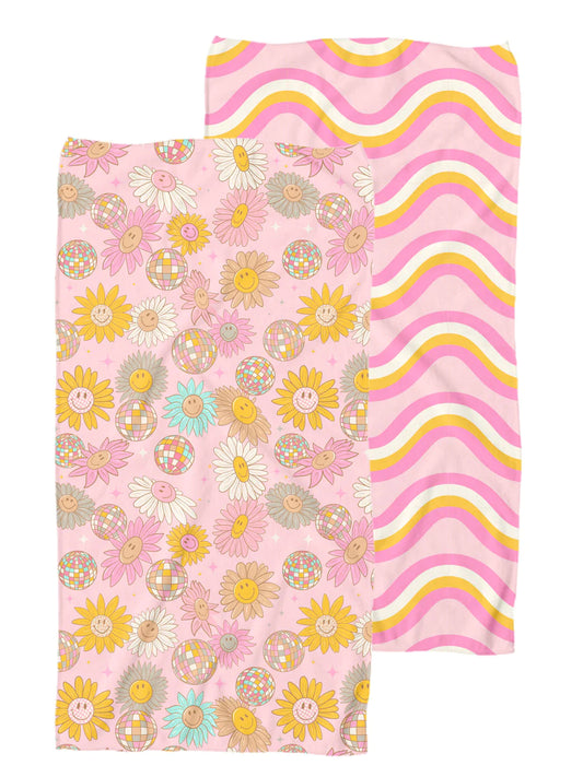 two sided towel. one side is pink base with multi colored smiley face flowers and disco balls. The other side is a pink base with orange, white, and fuchsia squiggly lines