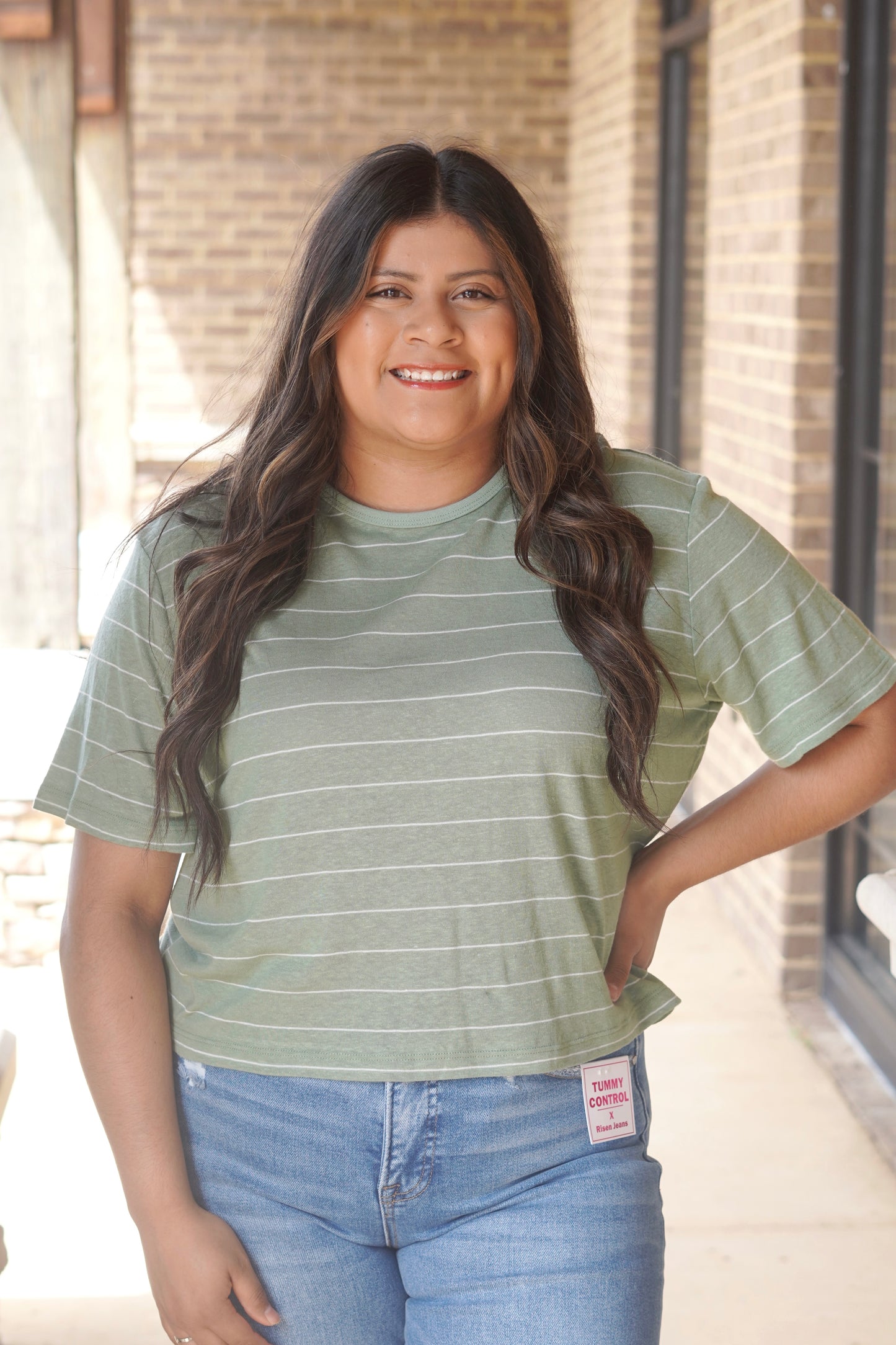 Women wearing a green and white striped crop short sleeve t-shirt.
