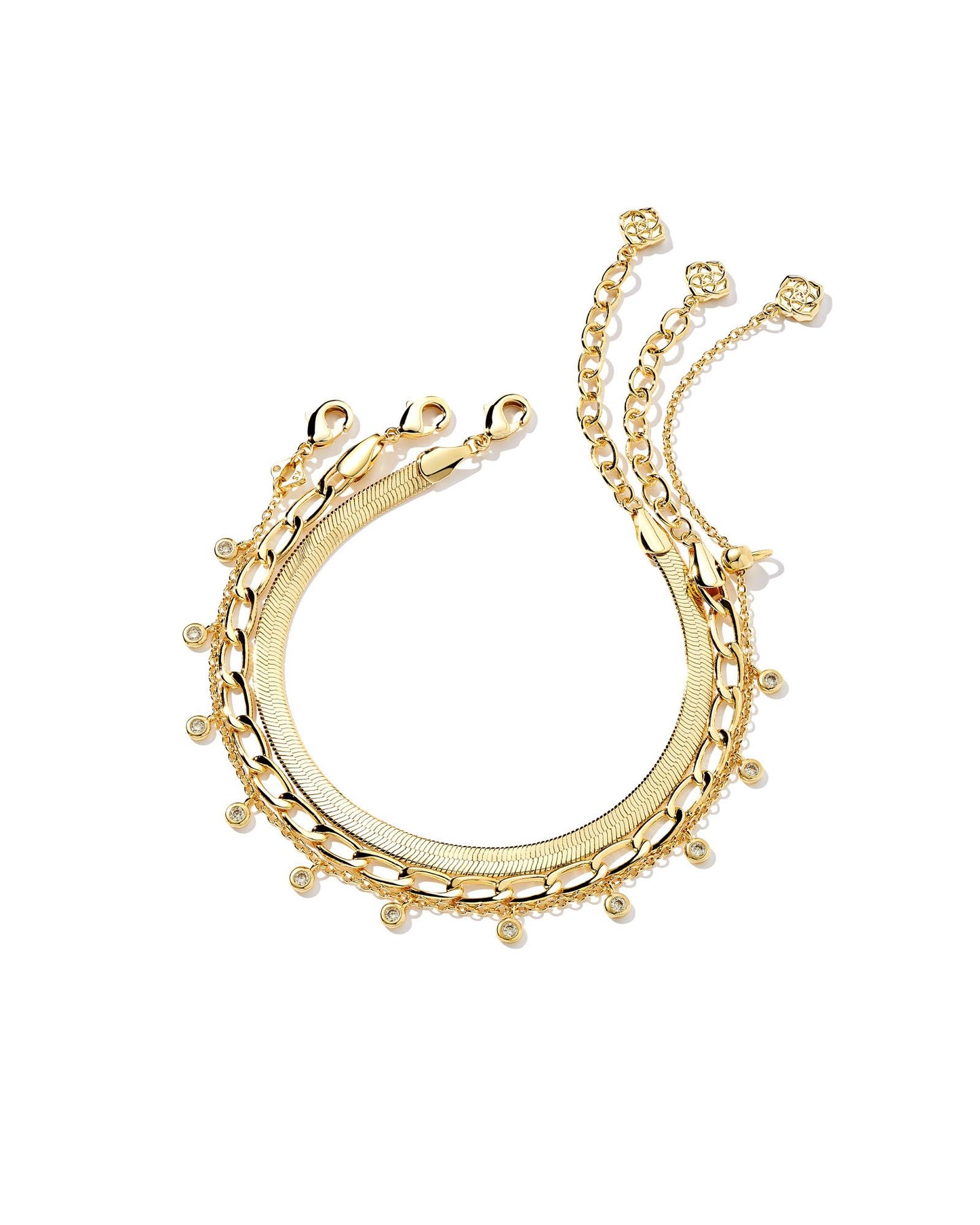 The Kassie Set of 3 Chain Bracelet in Gold features three classic chain links. Complete with a herringbone, paperclip, and crystal charm chain, wear altogether or curate your own bracelet stack.