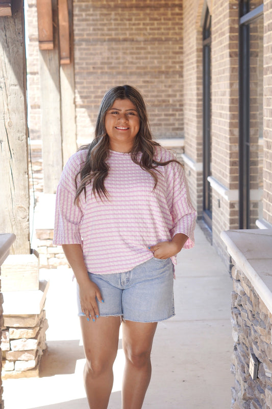 Women wearing a lavender Textured Striped Top, 3/4 Length Sleeve, Relaxed Fit paired with blue jean shorts.
