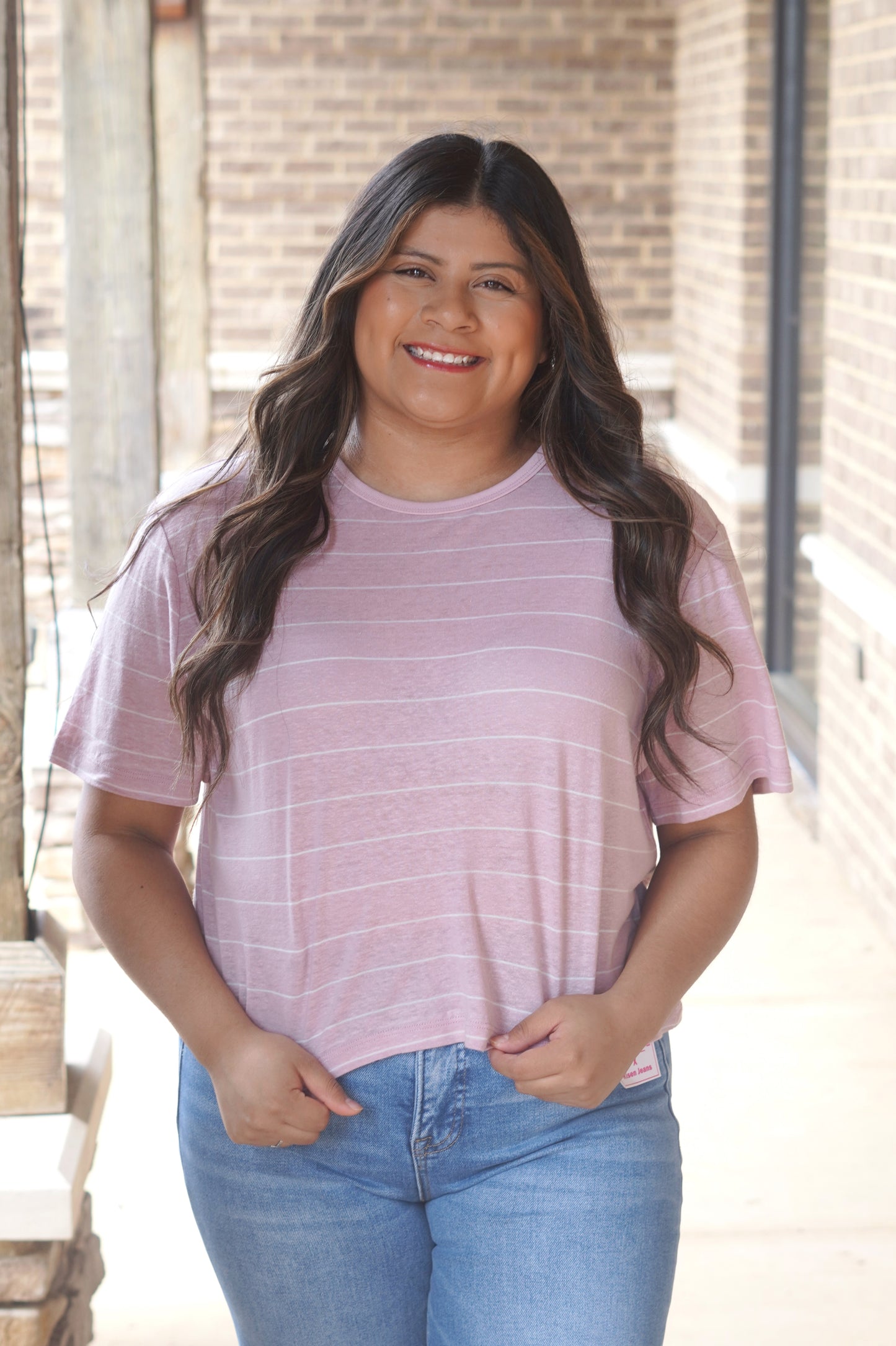 Women wearing a pink and white striped crop short sleeve t-shirt.