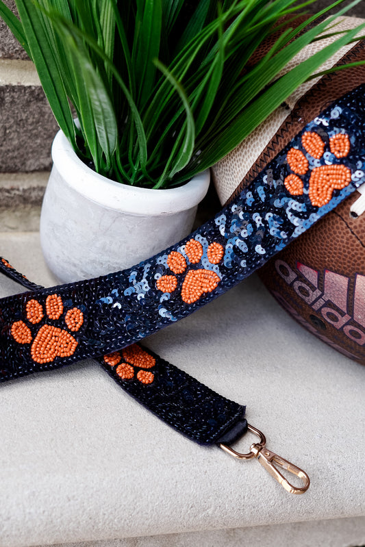 Clear bags can be such a bore when your outfit is on point for game day!! No fear, grab a Game Day Beaded Crossbody Strap whether you are Rolling with the Tide or headed to the Plains!! Sequin Game Day Strap 46.5" including gold hooks. Navy beaded strap with orange paw prints.