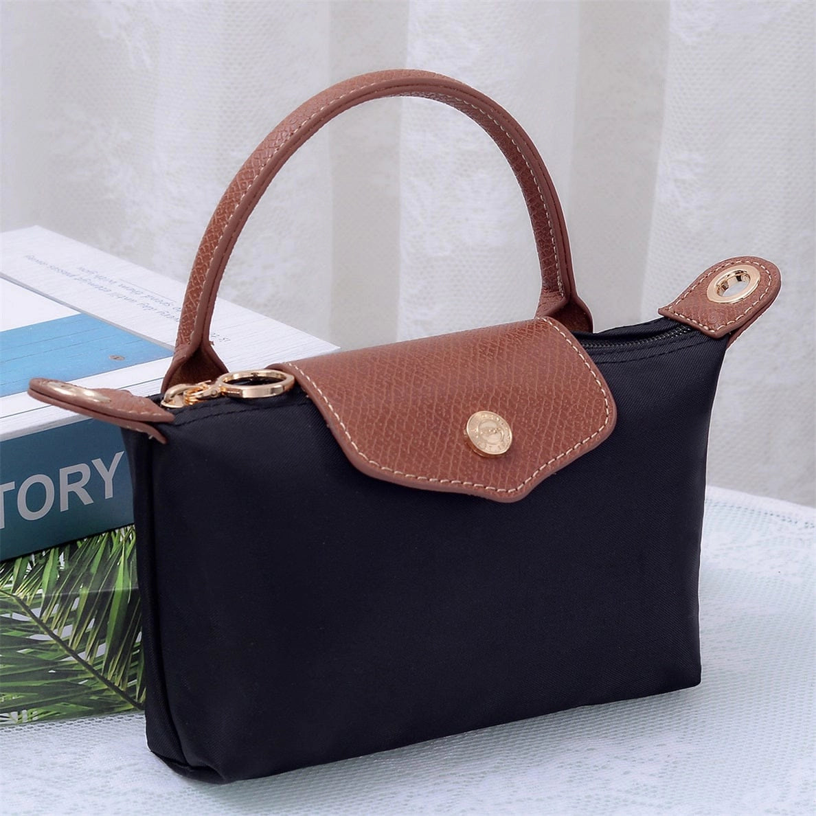 Small black handbag with brown leather and gold accents