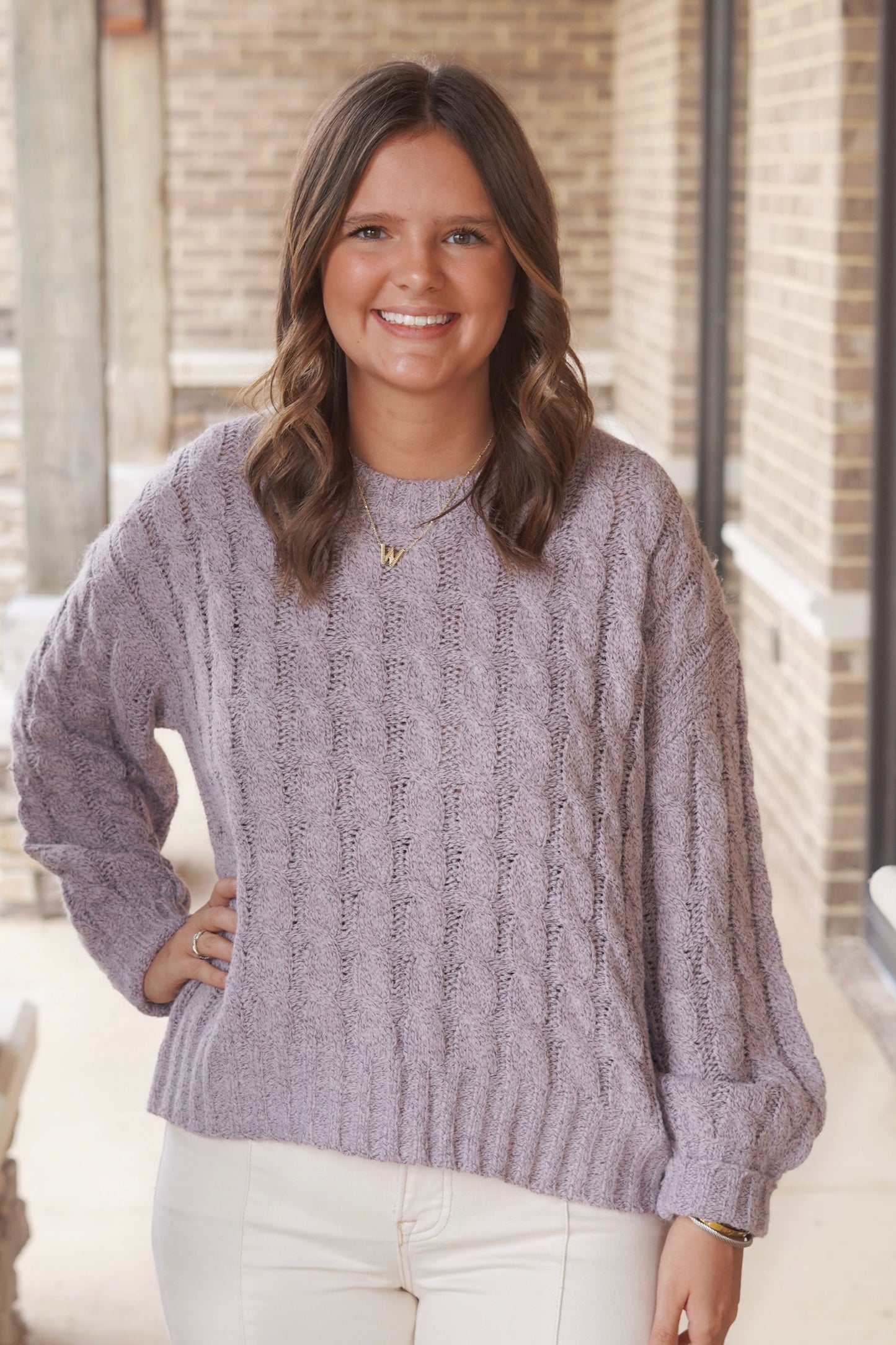 Woman wearing a light purple knit sweater paired with cream jeans