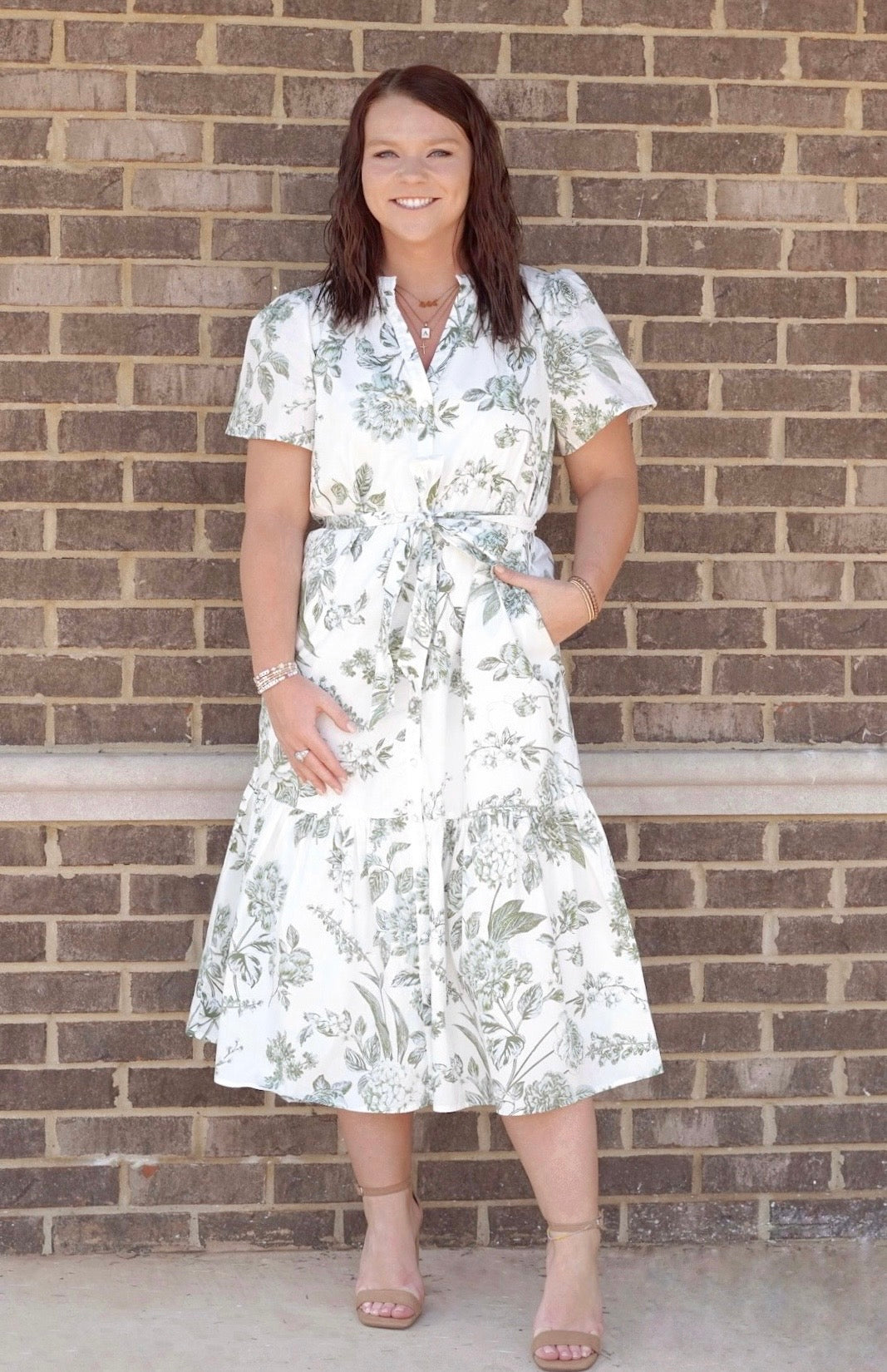White midi dress with olive green floral details. Functional tie at the waist. Short sleeves. V neckline.