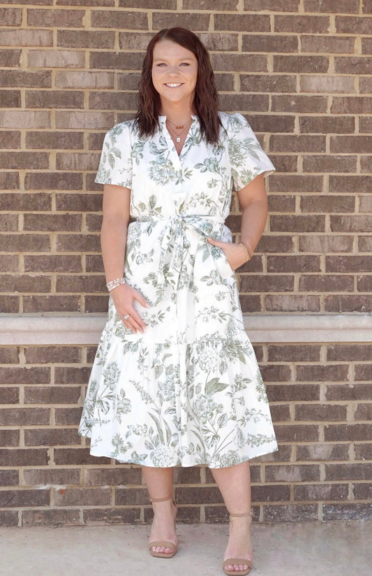 White midi dress with olive green floral details. Functional tie at the waist. Short sleeves. V neckline.