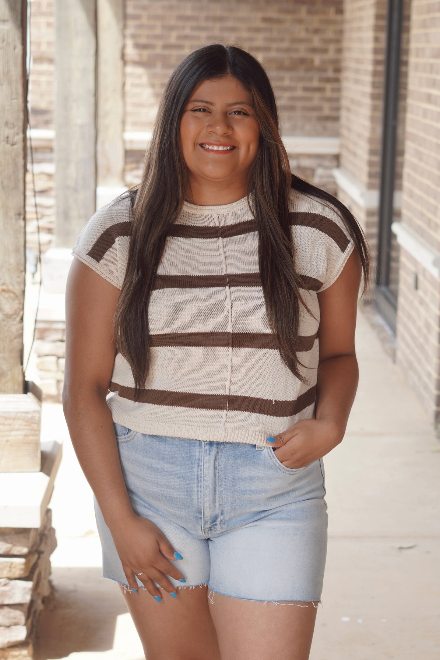 Women wearing cream and brown striped top with short sleeve, round neckline, knit material.