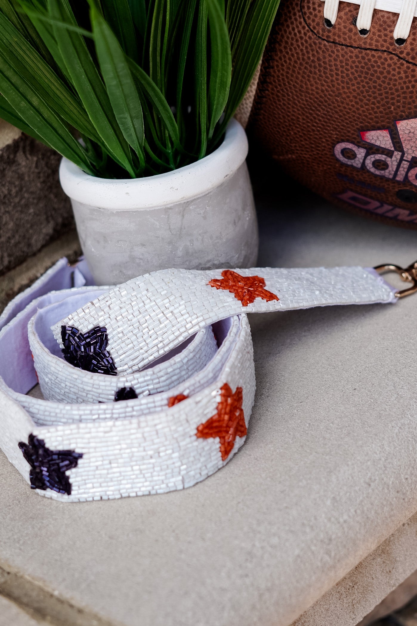 White beaded strap with orange and navy beaded stars.