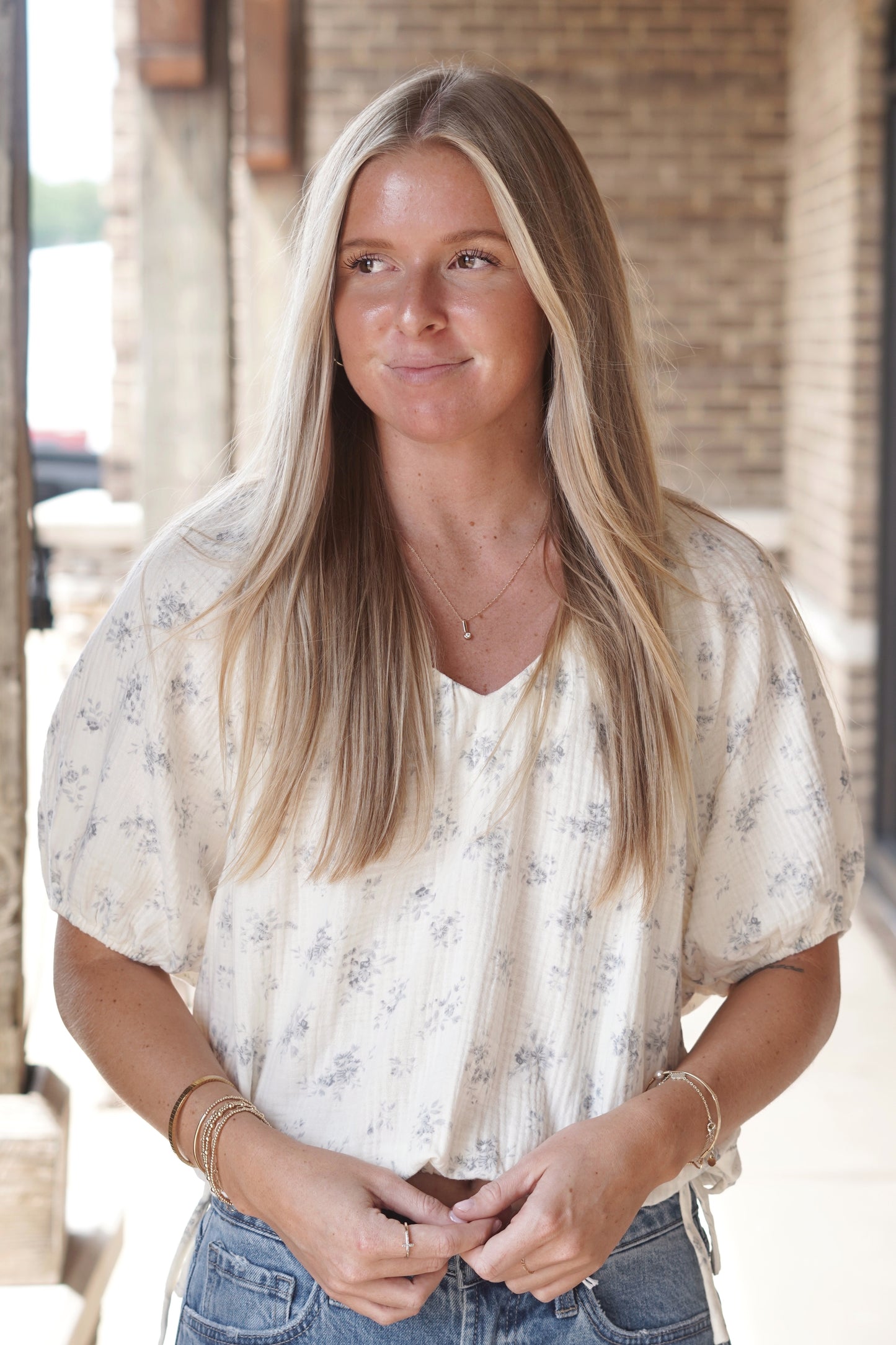 Cream top. Light blue small floral print. Functional ties at bottom of the shirt. Short sleeves. V neckline