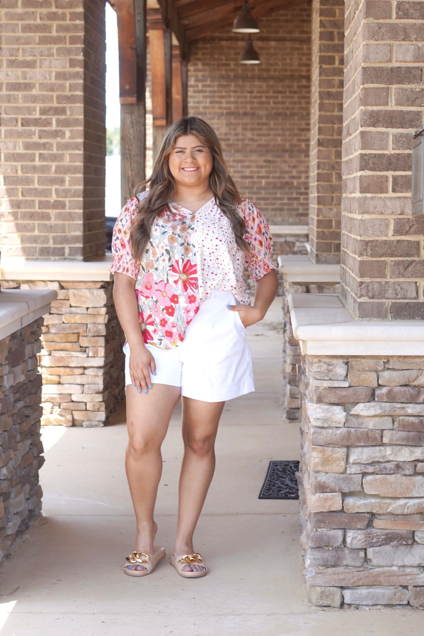 Short sleeve top with mixed floral print. One side is large florals in various colors of pink and white, other side is. very small florals in pink. Split right down the middle. V neckline.