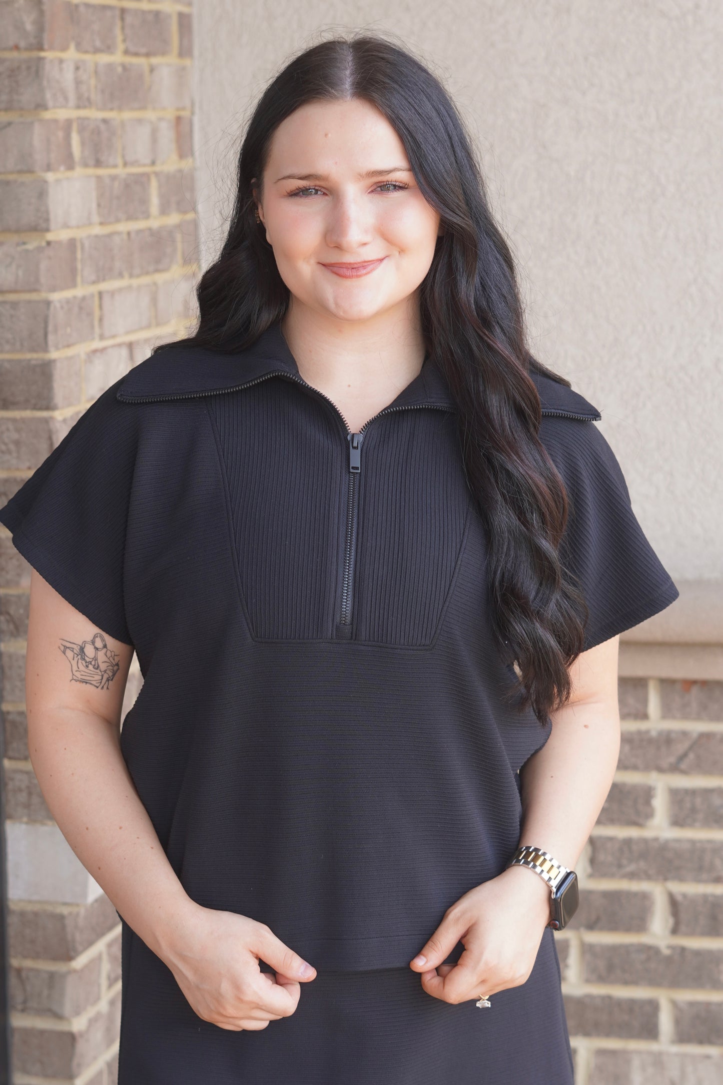 Women wearing a Black Ribbed Short Sleeve Half Zip, Collar Neckline.