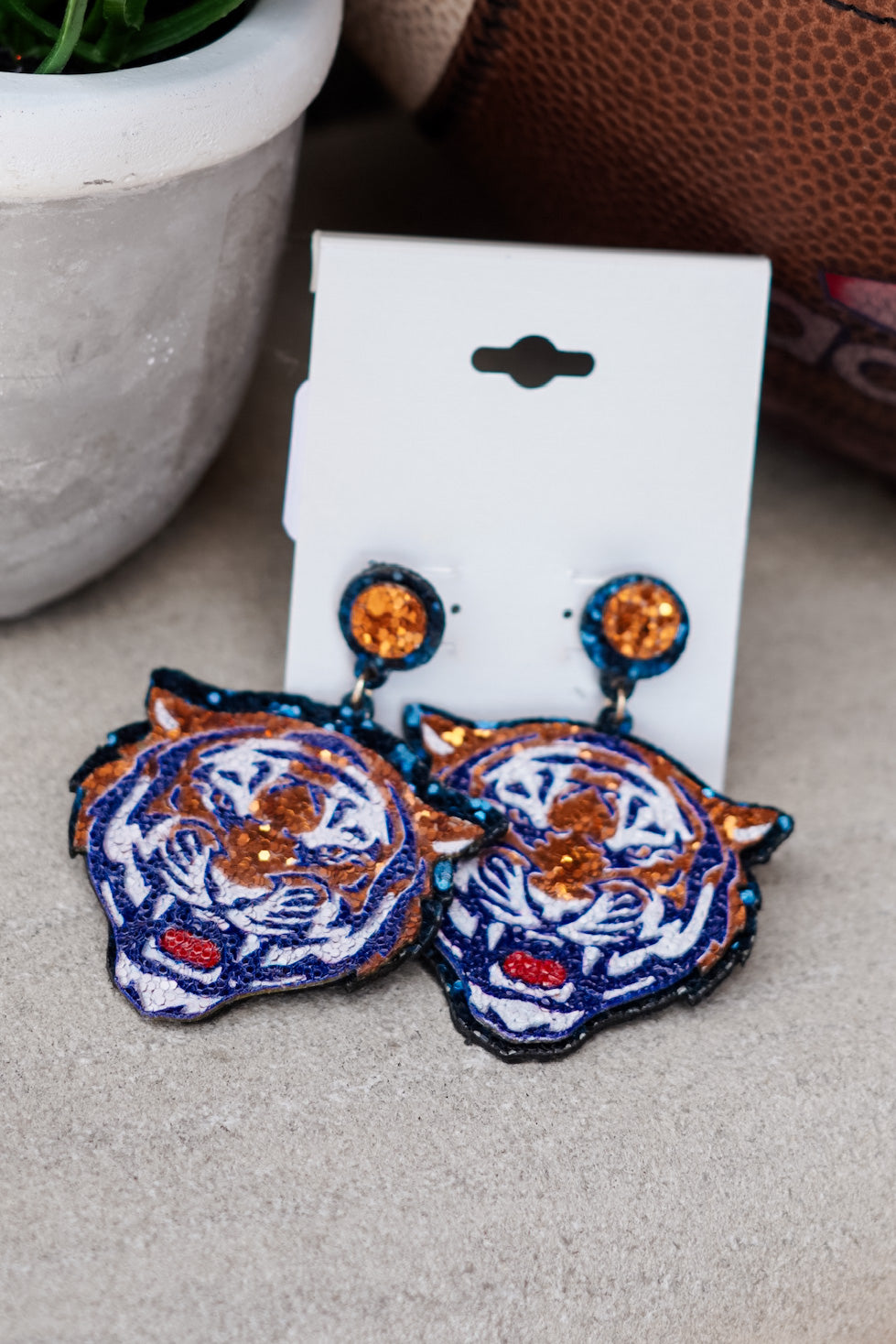 You're a glitter girl, and a Tigers girl!! Grab these Glitter Tiger Earrings to add to your favorite game day outfit!! Glitter Tiger Earrings Post Stud Back. Navy and orange tiger head beaded earrings.