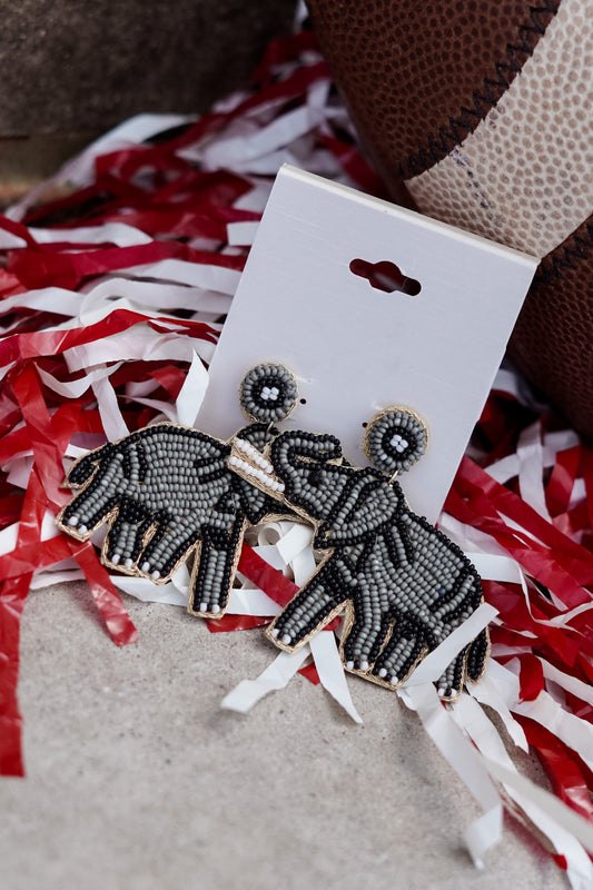 You are a lover of all things Elephant!! Whether you're just an animal lover or you are Rolling with the Tide, these earrings will make the perfect statement to any outfit. Wear them for Saturday Down South, or any time of the week!! Bryant Beaded Elephant Earrings Stud Post Back. Grey elephant beaded earrings with black outline with white tusks.