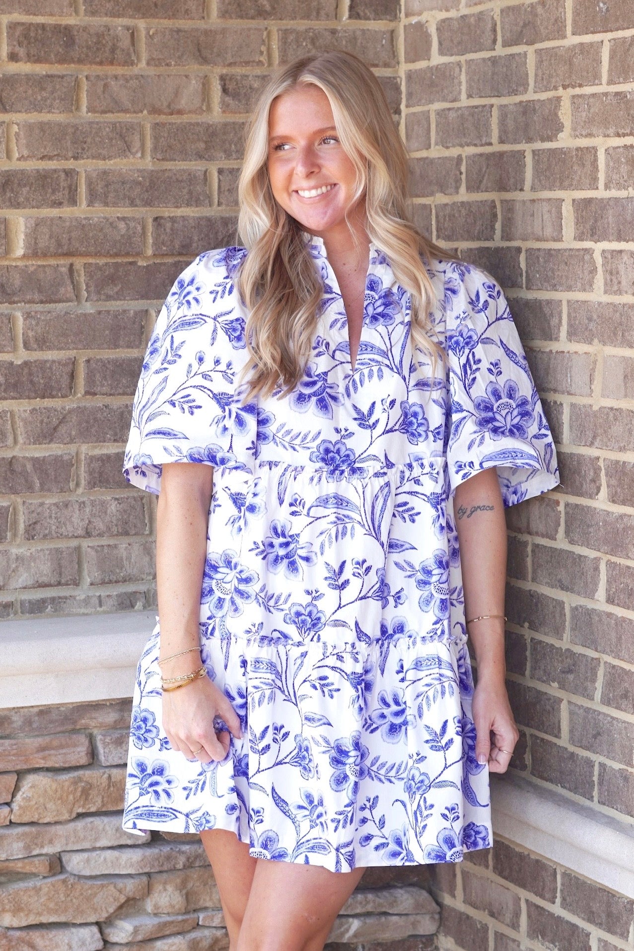 White tiered dress with royal blue floral and paisley print. Short sleeve. V-neckline. Hits above the knee.