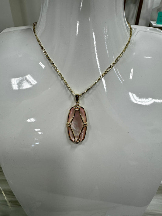 gold necklace featuring an oval, light pink pendant encased in a decorative gold wire .