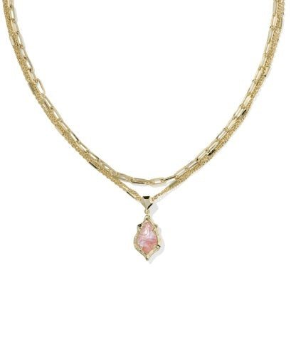 Gold necklace with a pink pendant on a white background