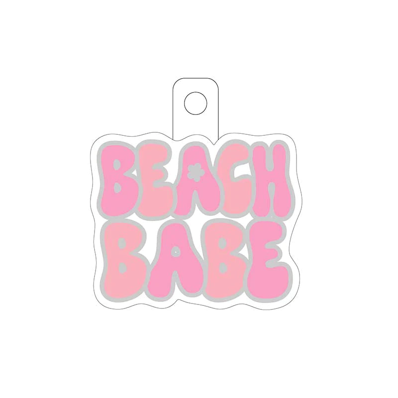 white stciker with the words "beach babe" scripted in pink