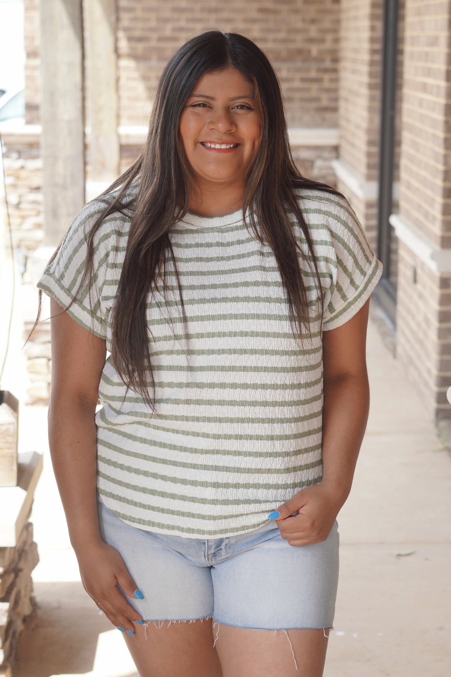 Women Wearing a Green Striped Short Sleeve Top, with a Round Neckline, and texture knit material.