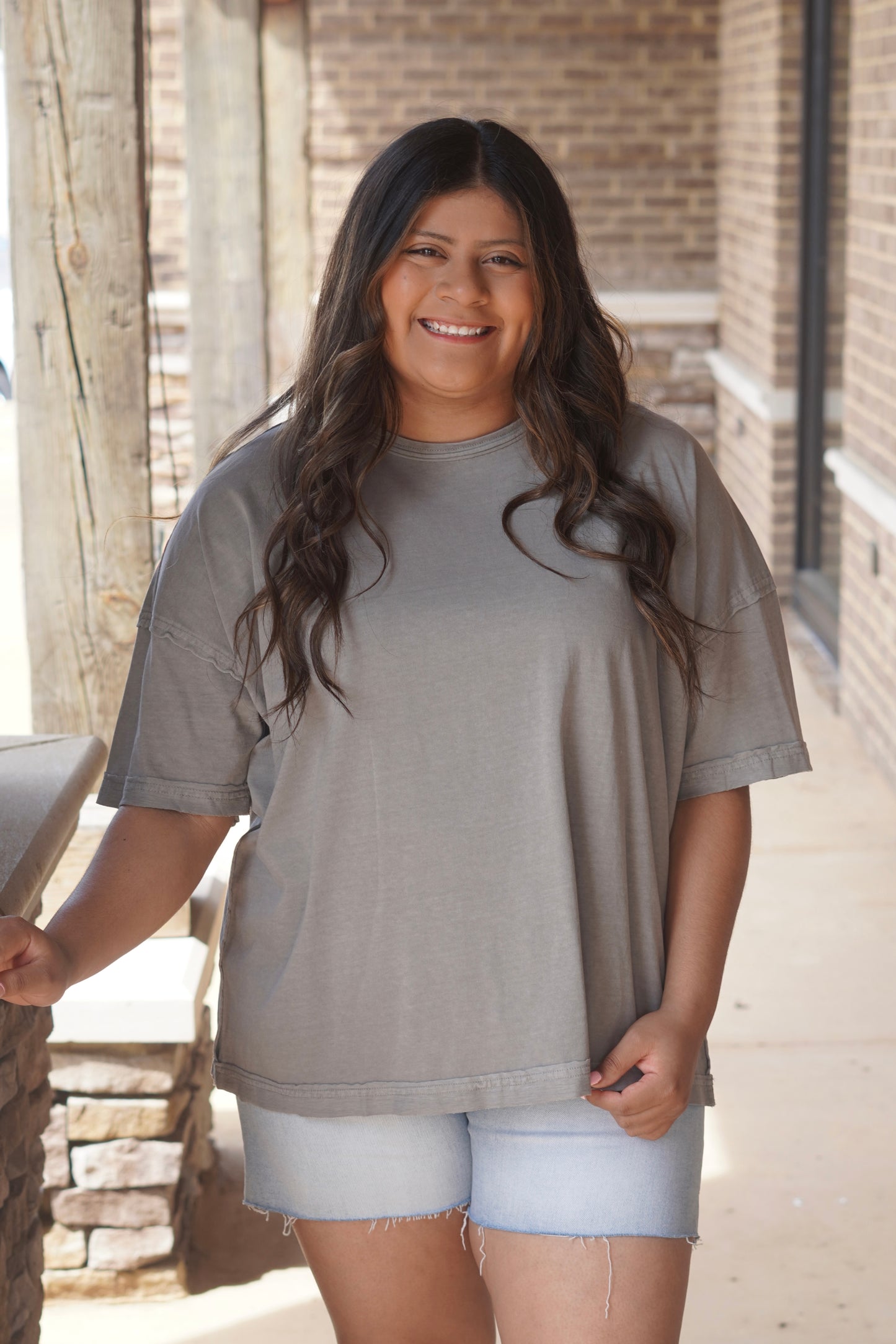 Women wearing a grey tee, short sleeve, round neckline, oversize.