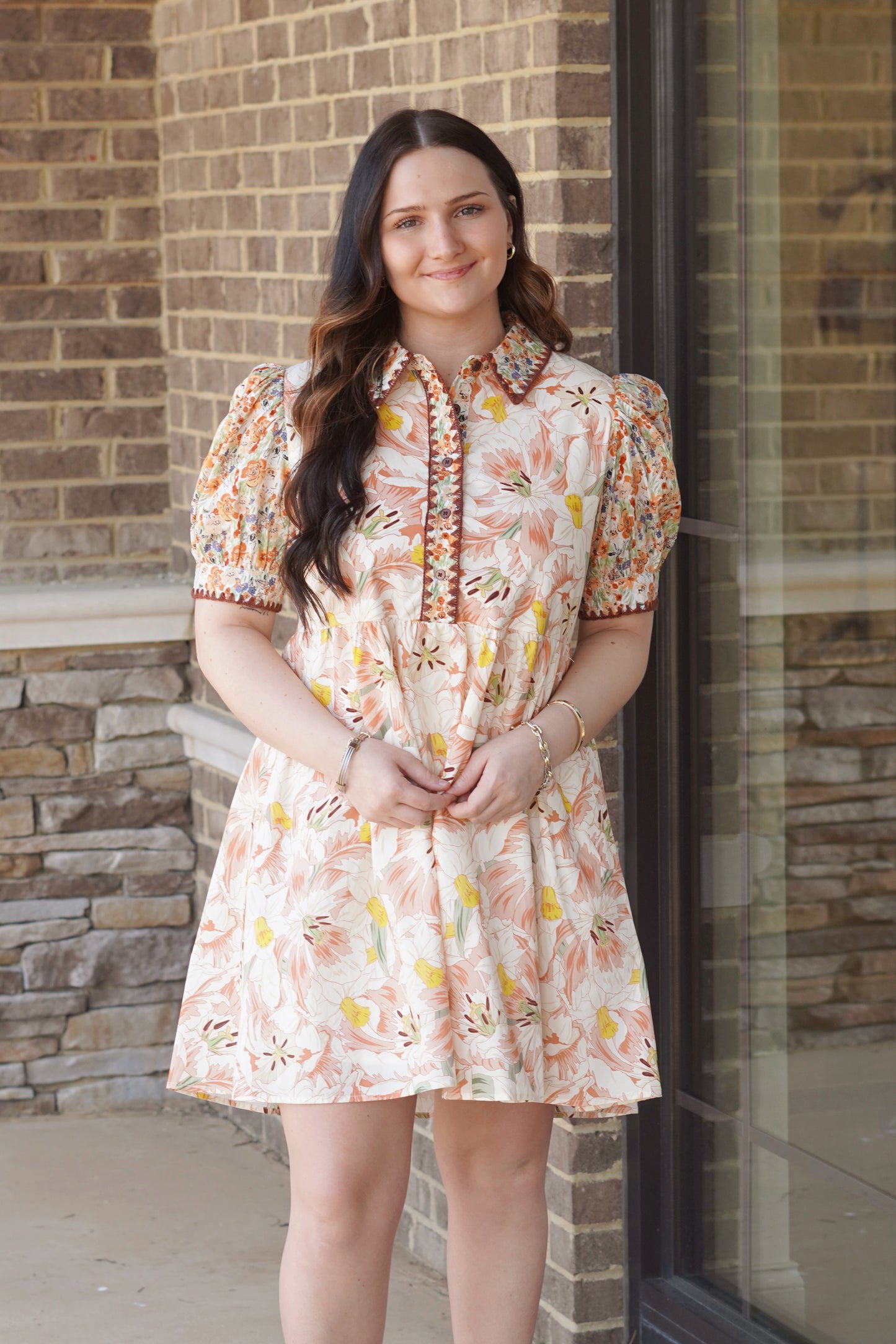 Women wearing a ivory floral print mini dress with short puff sleeves, and a collar neckline, flowy.