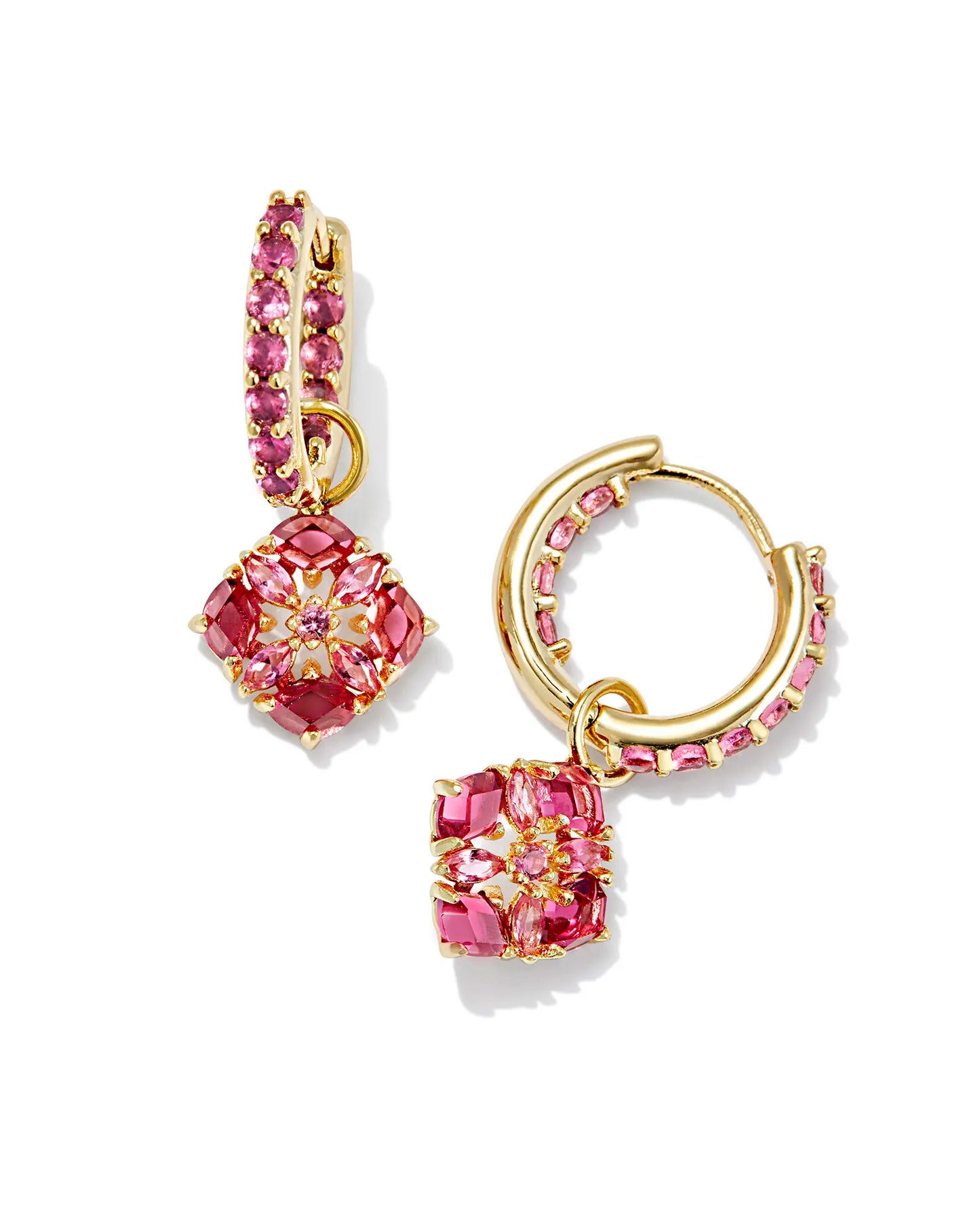 gold huggie earrings with pink crystal detailing and a flower charm that is pink crystal studded