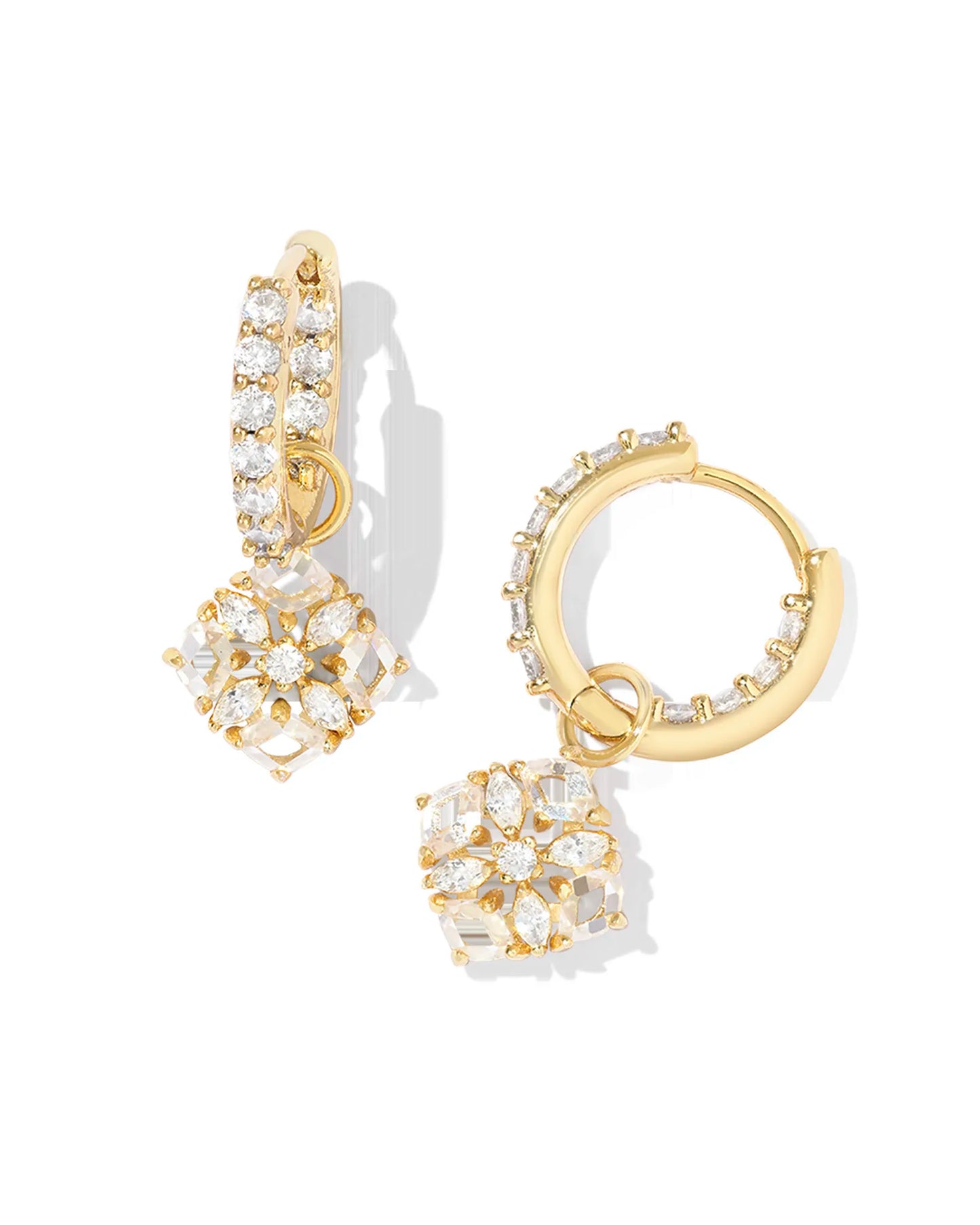 gold huggie earrings with studded white crystals and a studded white crystal flower charm