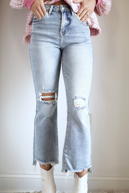 Harley High Rise Crop Flare Jeans High Rise Waistline Distressing on the Knee and the Hem of the Legs Light Denim Color Fitted Cropped Length 74% Cotton, 24% Polyester, 2% Spandex Care: Turn inside out, Machine wash cold, Tumble dry low, Gentle cycle with like colors, Do not bleach, Hang to dry, Indigo will bleed, Iron if needed