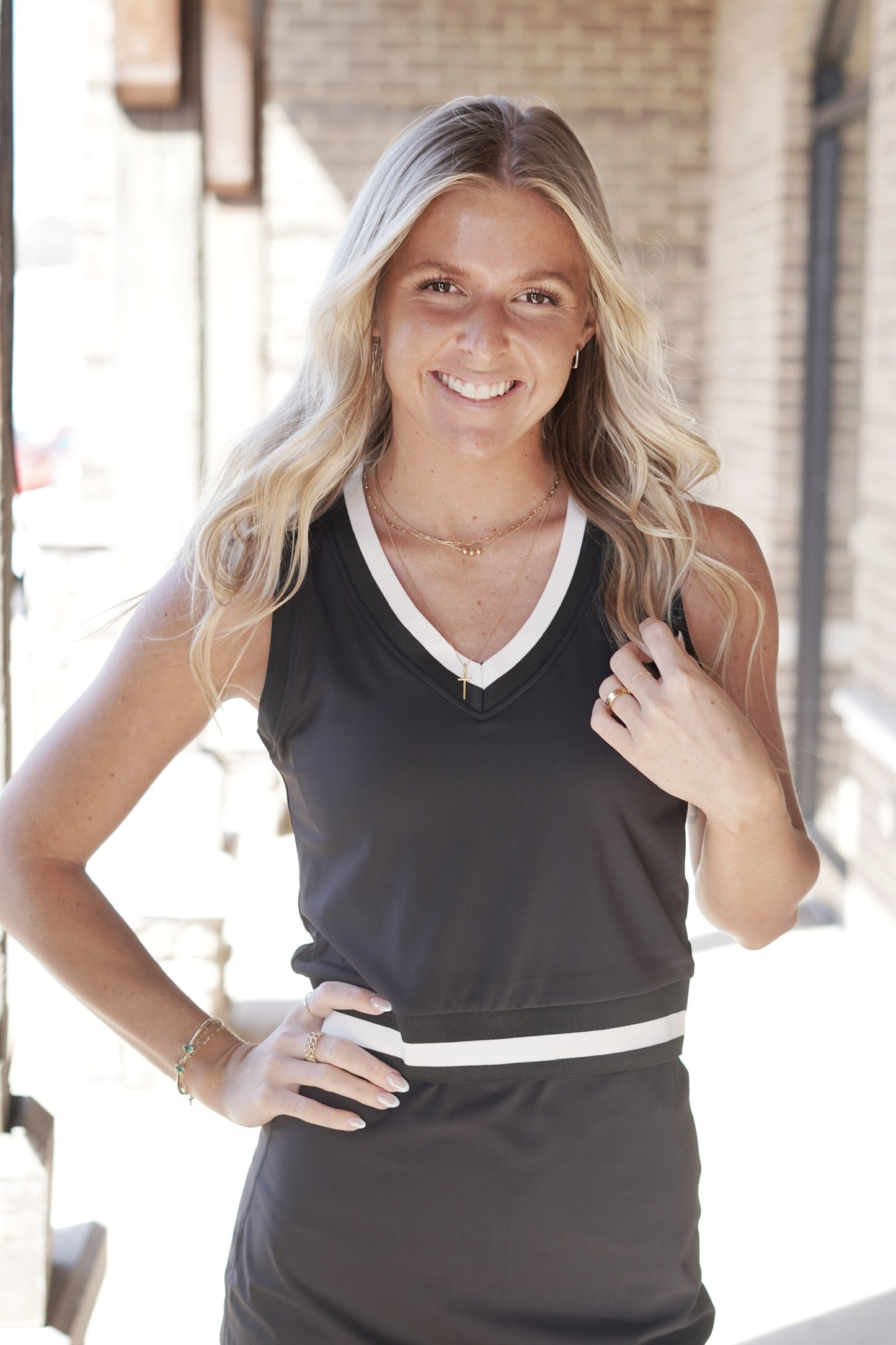 <ul> <li>Stay Active V Neck Tennis Top</li> <li>V Neck Line</li> <li>Sleeveless</li> <li>Pink/White Stripe Trim</li> <li>Full Length</li> <li>Built In Bra Pads</li> <li>Colors: Black/White, </li> <li>True To Size</li> <li>Fitted</li> <li>85% Recycled Nylon, 15% Spandex</li> </ul>