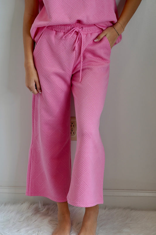 You and your bestie signed up for an outdoor yoga class, now that the heat has died down, but you have no idea what to wear. Don’t worry girlfriend, simply throw on Maci Textured Cropped Pants, and get your downward dog on. Maci Textured Cropped Pants Wide Legged Bubble Gum Pink Pairs with a Matching Top 83% Polyester 15% Rayon 2% Spandex Hand Wash, Do Not Bleach, Tumble Dry Low, Low Iron If Needed