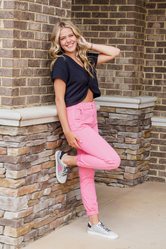 Belle High Rise Pink Jogger Jeans Cuffed Ankle Pink Line Detail Down the side Button and Zipper Closure Front and Back Pockets 92% Cotton 6% Polyester 2% Spandex Turn inside out, Machine wash cold, tumble dry low, gentle cycle with colors, Do not bleach, hang to dry, Indigo will bleed, iron if needed Model Wearing Size 1