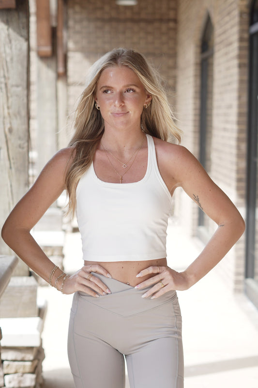 <ul> <li>Gold Hinge Racerback Cropped Tank</li> <li>Scoop Neckline</li> <li>Sleeveless</li> <li>Racerback</li> <li>Built In/ Removable Padding</li> <li>Colors: White</li> <li>Cropped</li> <li>Fitted</li> <li>75% Nylon, 25% Spandex</li> </ul>