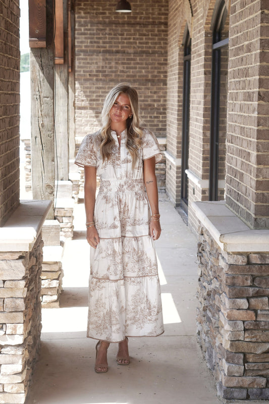 Cecelia Cinched Waist Printed Maxi Dress Skinny Slit V-Neckline Cap Sleeves Cinched Waistline Color: White w/ Latte Colored Toile Print Latte Colored Trim Maxi Length Tiered Style 100% Cotton