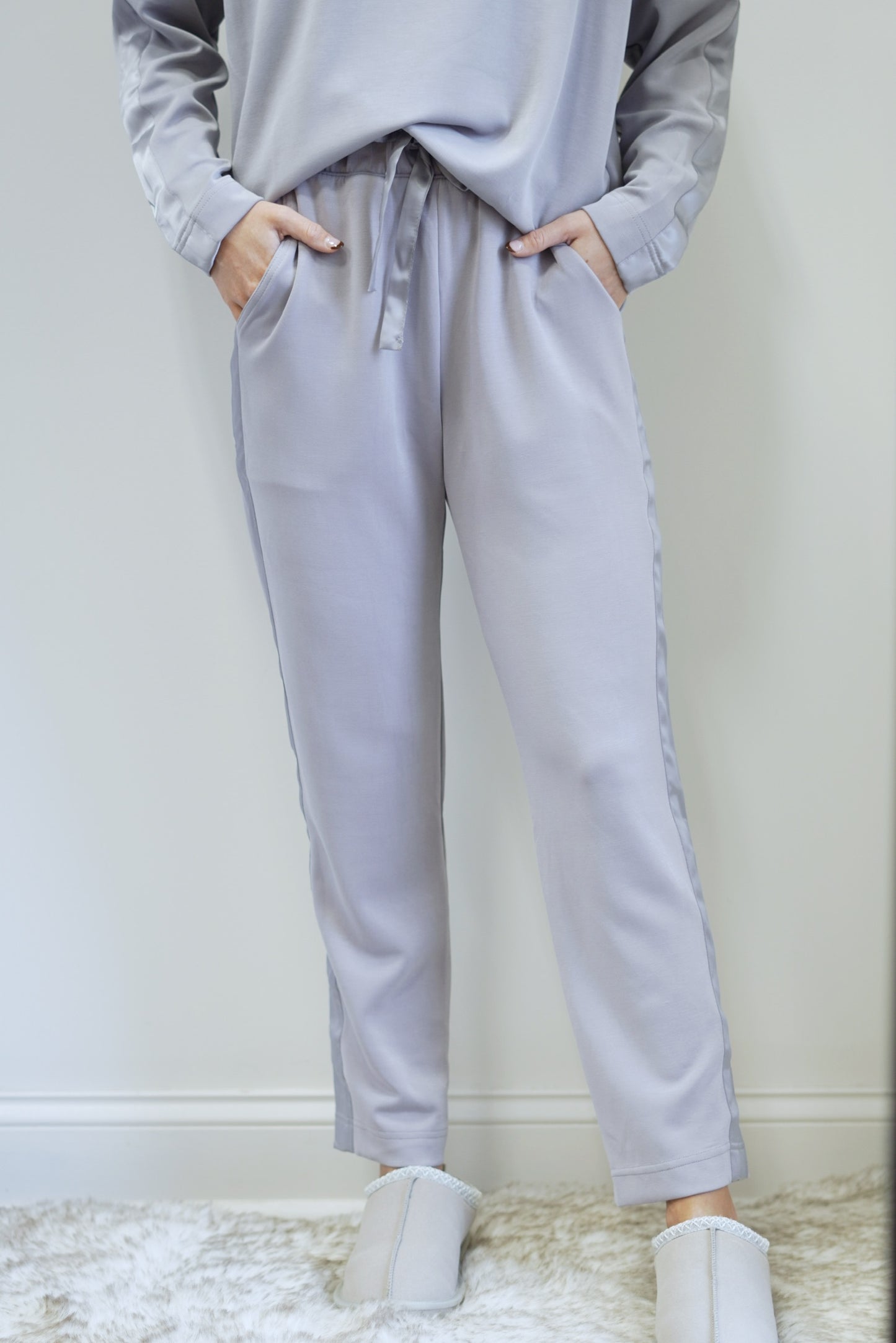 So Sleek Satin Trim Athletic Pant Mid Waisted Elastic Waistband with Tie Satin Trim Detail on Side of Legs Colors: Mystic Grey Tapered Pant Ankle Length Relaxed Fit 48% Modal, 46% Polyester, 6% Spandex