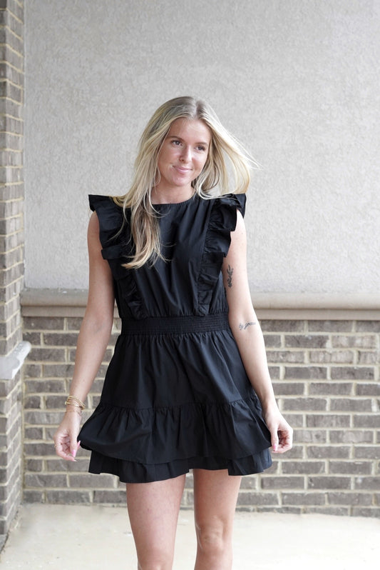 <ul> <li>Rylie Round Neck Ruffle Sleeve Dress</li> <li>Round Neckline</li> <li>Sleeveless</li> <li>Ruffle Short Sleeves</li> <li>Elastic Waistband</li> <li>Color: Black</li> <li>Mid Thigh Length</li> <li>Back Button Closure</li> <li>100% Cotton</li> </ul>