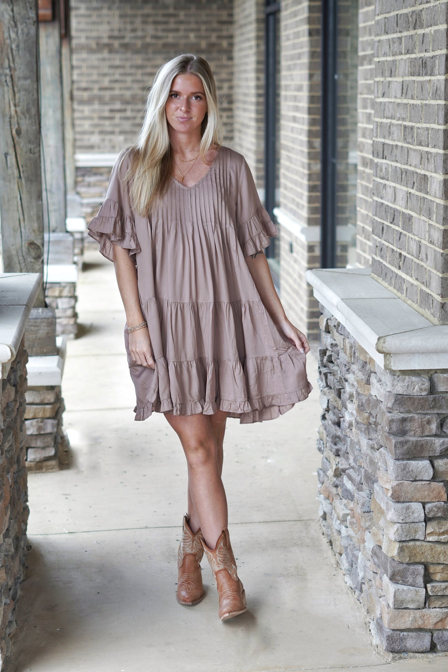 <ul> <li>Rae Ruffle Sleeve Tiered Dress<br></li> <li>V-Neckline</li> <li>Short Ruffle Sleeves</li> <li>Pleated Bodice</li> <li>Pockets</li> <li>Tiered Ruffle Detail</li> <li>Color: Mushroom</li> <li>Above the Knee Length</li> <li>Relaxed Fit</li> <li>65% Polyester, 35% Rayon</li> </ul>
