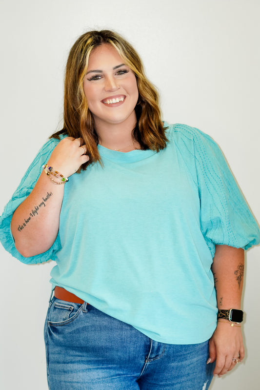 Sarah Lush Relaxed Top with Stitched Sleeves Round Neckline Bubble Middle Length Sleeves with Stitched Detail Relaxed Fit Sizes 1XL-3XL 62% Polyester, 34% Rayon, 4% Spandex
