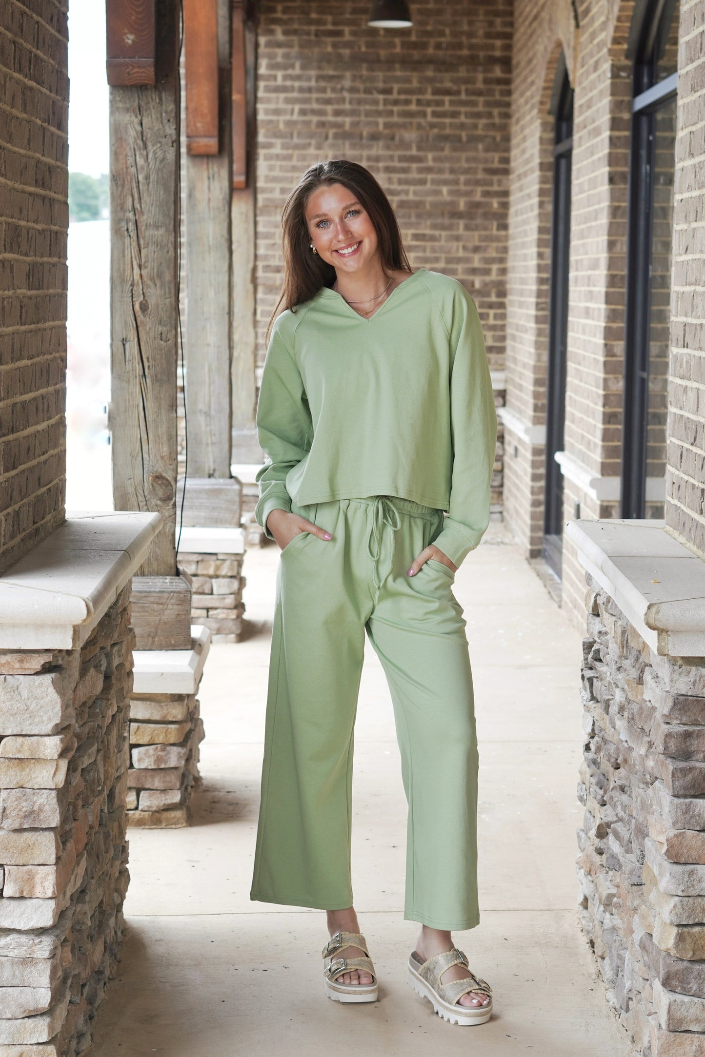 Top Slit V-Neckline Long Cuffed Sleeves Color: Light Olive Full Length Relaxed Fit Pants Mid-Waisted Adjustable Drawstring Pockets Ankle Length Relaxed Fit Color: Light Olive 57% Cotton, 41% Polyester, 2% Spandex
