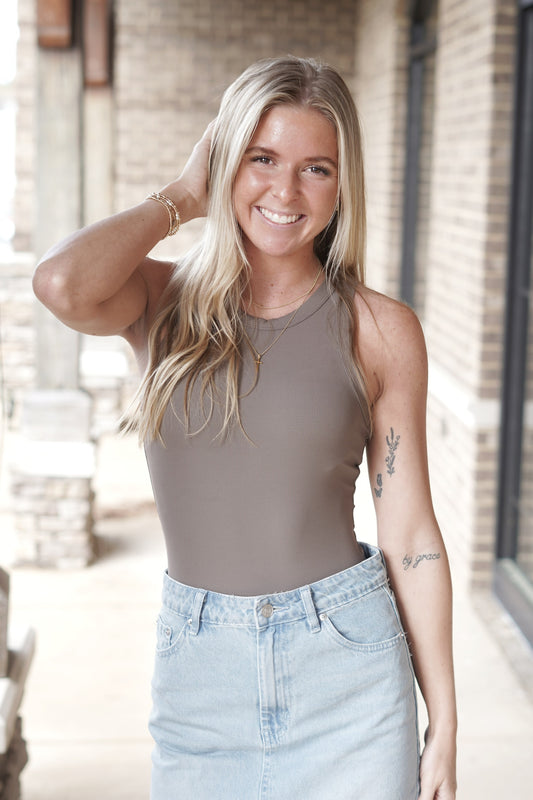 <ul> <li>Spanx Suit Yourself Racer Ribbed Bodysuit</li> <li>Fitted to the body</li> <li>Rounded Neckline</li> <li>Soft ribbed fabric</li> <li>Sleeveless</li> <li>racerback</li> <li>Core-smoothing design</li> <li>Colors: smoke</li> <li>Bodysuit</li> <li>Fabric Content: <span data-mce-fragment="1">66% Polyester, 34% Elastane. Gusset: 100% Cotton</span></li> </ul>