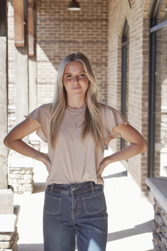 <ul> <li>Abby Flutter Tee</li> <li>Round Neckline</li> <li>Cap Flutter Sleeves</li> <li>Raw Hem Detail on the Sleeves</li> <li>Color: Iced Coffee</li> <li>Relaxed Fit</li> <li>Full Length</li> <li>60% Cotton, 40% Polyester</li> </ul>