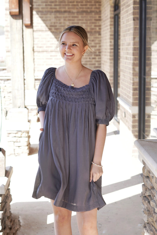 <ul> <li>Sully Smocked Puff Sleeve Dress</li> <li>Square Neckline</li> <li>Short Puff Sleeves</li> <li>Pockets</li> <li>Smocked Bodice</li> <li>Color: Faded Navy</li> <li>Babydoll Fit</li> <li>Knee Length</li> <li>100% Polyester</li> </ul>