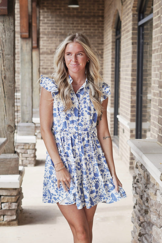 Brynn Blue Floral Print Dress Ruffle Half Sleeves Collar Neckline Button Down Dress Ruffle Detail Color: Cream With Blue Floral Print Mid Thigh Length True To Size Flowy Fit Dress Underlining Fabric Content: 100% Polyester Lining, 100% Polyester
