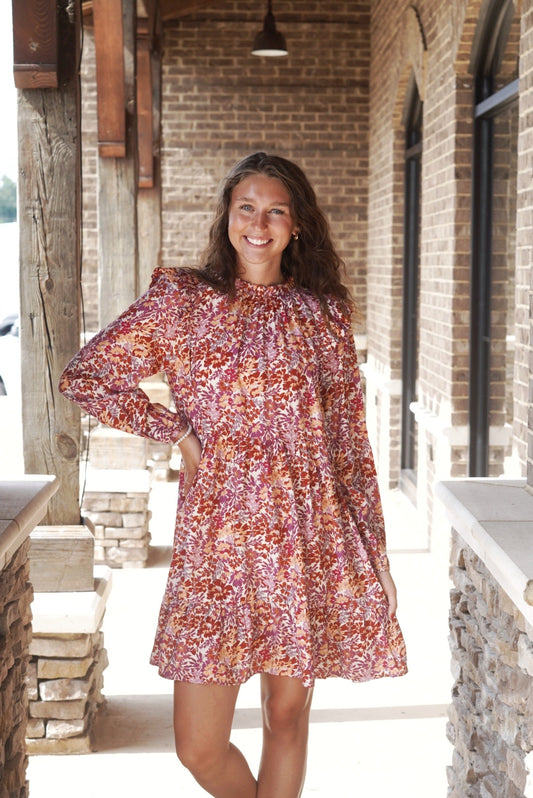 Molly Mock Neck Floral Dress Mock Ruffle Neckline Long Cinched Sleeves Color: Maroon Multi Floral Babydoll Fit Mid-Thigh Length Ruffle Detail 85% Rayon, 15% Nylon