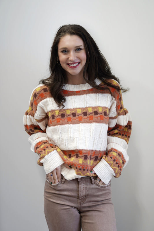 Kori Cable Trim Vintage Print Sweater Round Neckline Long Puff Cuffed Sleeves Vintage Print Colors: Cream, Orange, Brown, Yellow Skimmer Length Relaxed Fit 100% Polyester