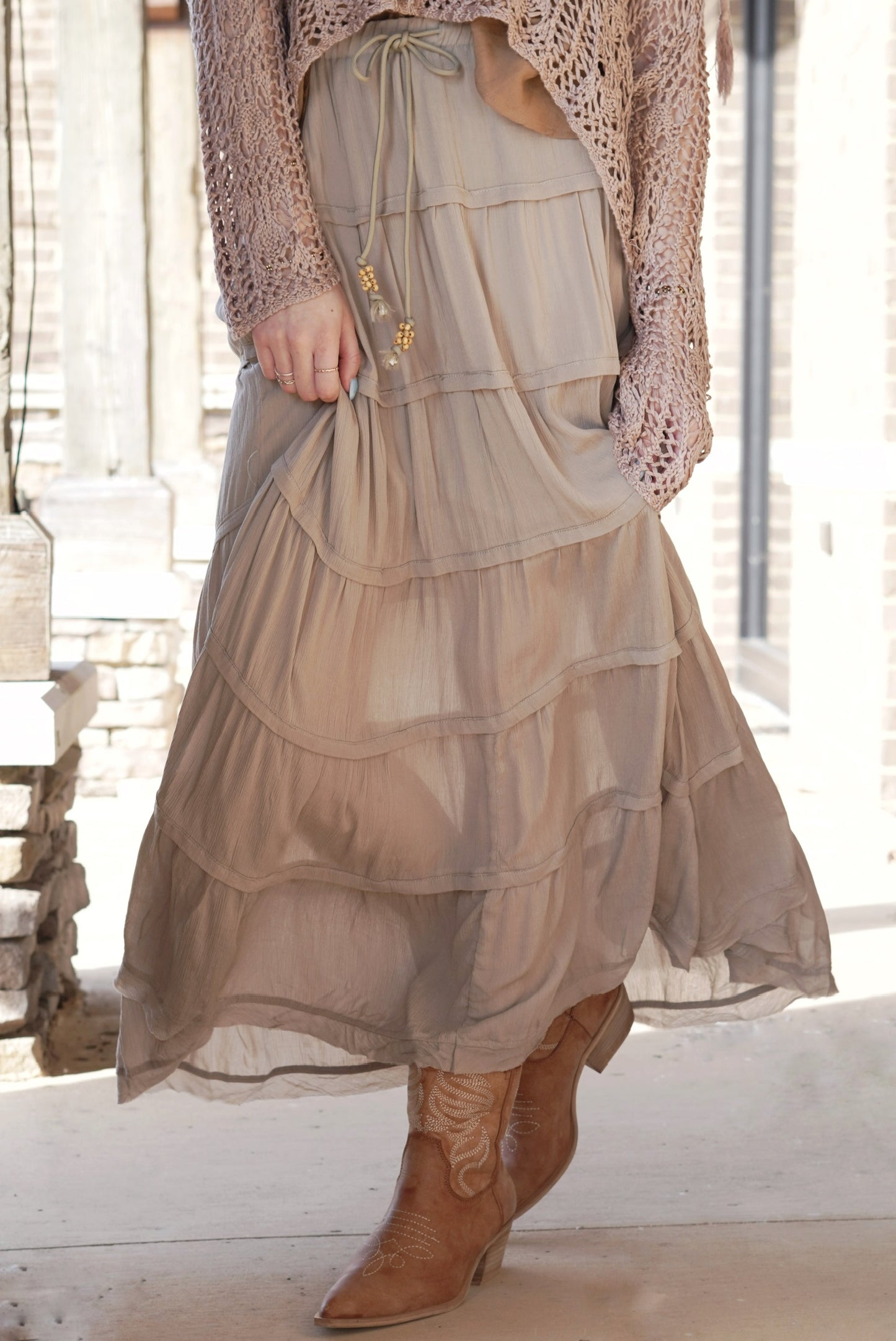<ul> <li>Traveler Tiered Ruffle Maxi Skirt</li> <li>Elastic Waistband w/ Tie</li> <li>Beaded Tassel on Waist Tie</li> <li>Tiered Ruffle Design</li> <li>Color: Olive Green </li> <li>Silky Gauze Material</li> <li>Relaxed Fit</li> <li>Silky Underlining</li> <li>Maxi Length</li> <li>100% Rayon</li> </ul>