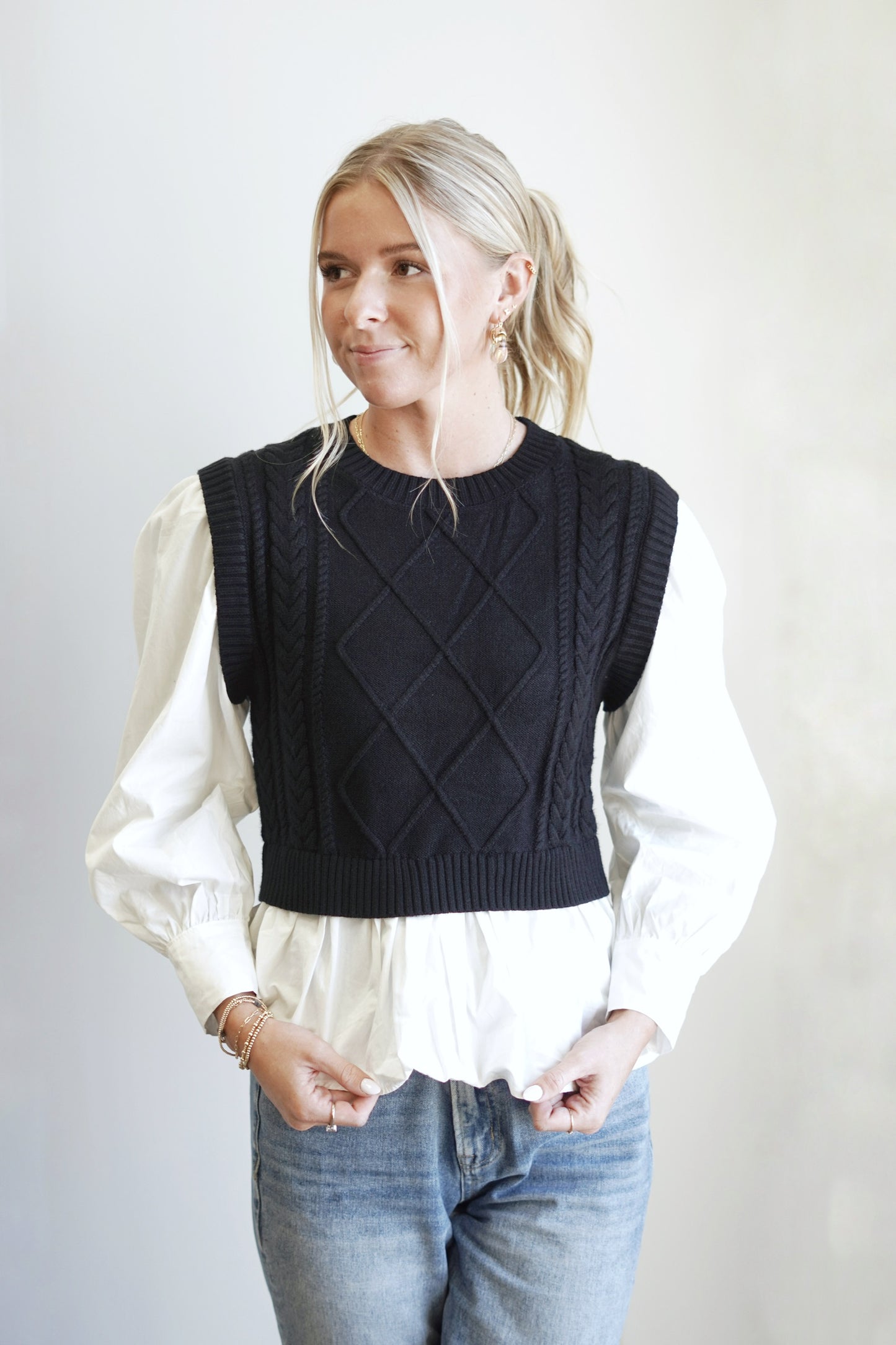 Brae Black Cable Knit Sweater Layered Shirt Crew Neckline Long Cuffed Sleeves Black Cable Knit Vest Layered Over White Shirt Relaxed Fit Full Length 100% Viscose