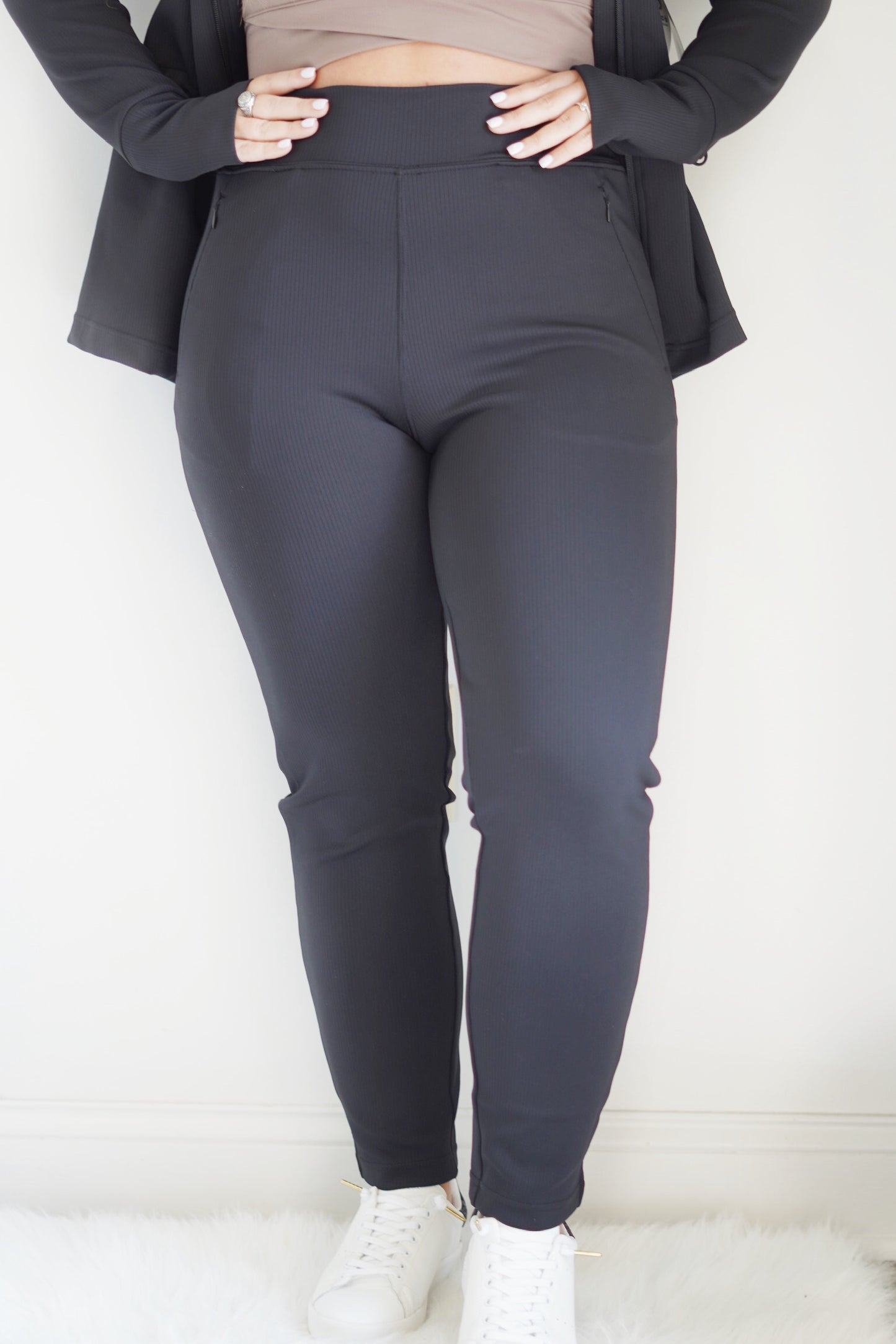 Reyna Ribbed Tapered Pant High Waist Tapered Leg Zipper Pockets Colors: Black and Natural Full Length 80% Polyester, 20% Spandex Machine Wash Cold, Tumble Dry Low, Do Not Iron, Do Not Dry Clean Model is wearing a size medium