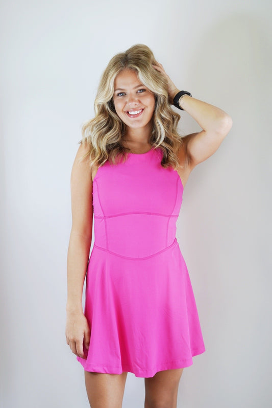 Tiff Butter Soft Tennis Dress Round Neckline Sleeveless Built in Spandex Shorts w/ Pockets Built in Bra Padding Cross Straps in the Back Hot Pink Color Slim Fit 84% Poly Microfiber, 16% Spandex