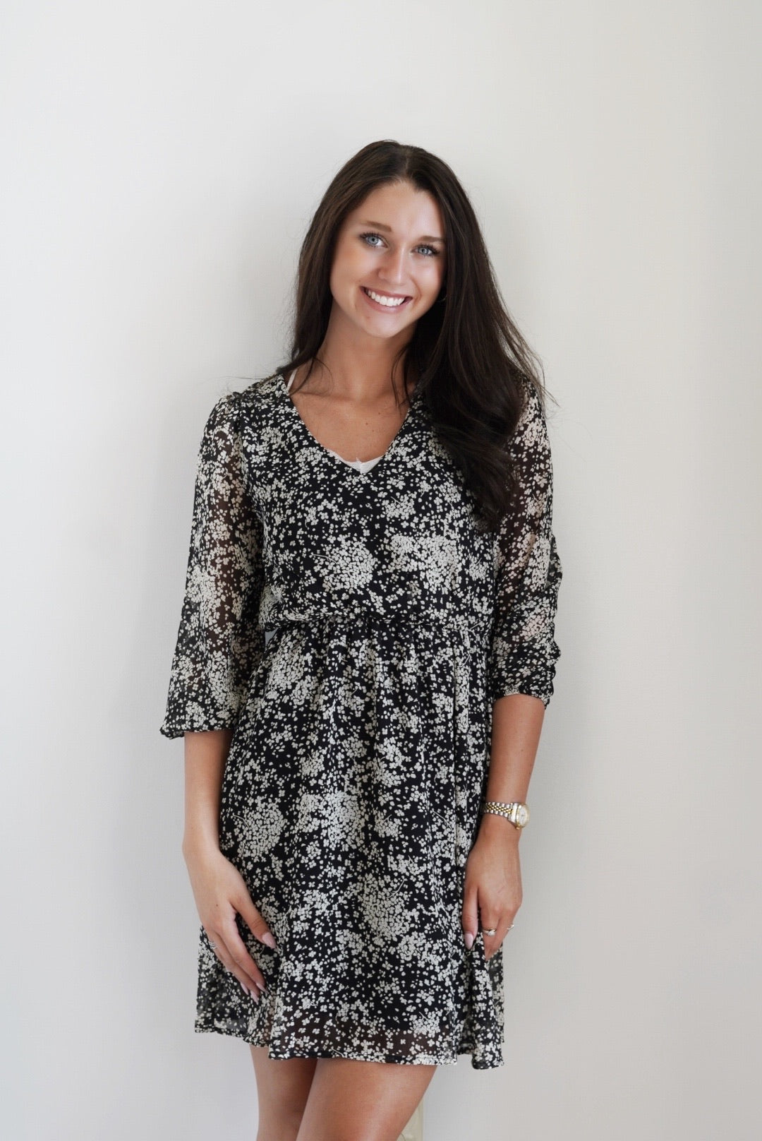 Fiona Floral Sheer Sleeve Dress V-Neckline 3/4 Length Sleeves Sheer Sleeves Black Color with White Floral Design Knee Length Cinched Waistline Flowy Fit 100% Polyester