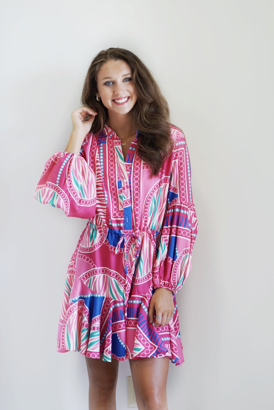 Lauren Adjustable Balloon Sleeve Dress Split Neckline Long Sleeved with Elastic Cuffs Drawstring Waist Band Front Button Closure Lined Skirt and Unlined Top and Sleeves Fuchsia Print Billowy Fit Mini Skirt 97% Polyester 3% Spandex Hand Wash Cold, Do Not Bleach, Lay Flat To Dry, Cool Iron If Needed Model Is Wearing a Size Small